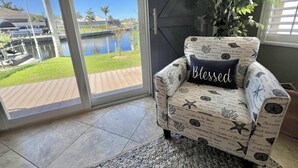 A chair with a nautical theme, a view of a water body, and a flag. - TOP FLORIDA's Villa Pelican Point (Cape Coral)