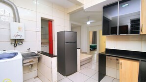 A compact kitchen with a built-in washing machine, a refrigerator, and a microwave. - Domingos (Rio de Janeiro)