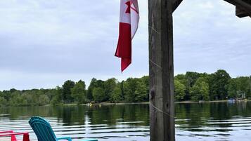 Relax on the lakeside dock with a serene view, surrounded by lush greenery and a tranquil atmosphere.