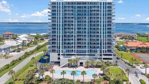 Un hôtel de grande hauteur doté de nombreux balcons, d’une piscine et offrant une vue sur l’océan.