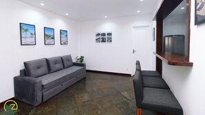 Ein modernes Interieur mit einem grauen Sofa, einem kleinen Tisch und einer Bank.