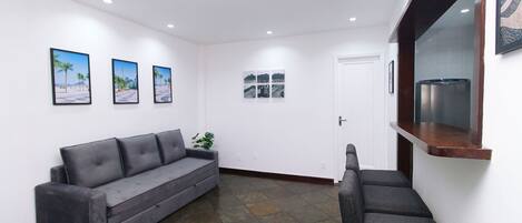 A modern interior with a grey sofa, a small table, and a bench.