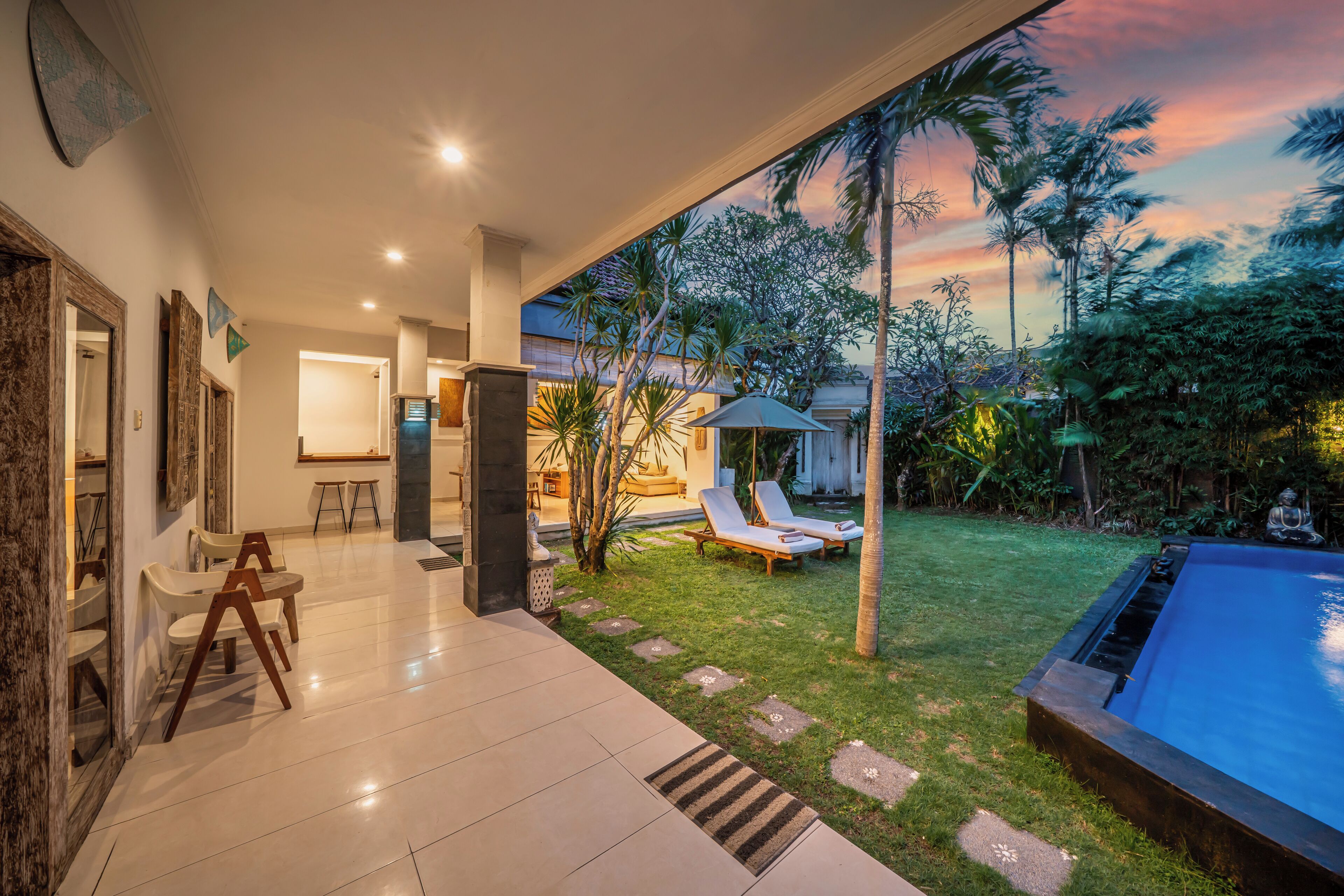 A modern house with a spacious patio, a swimming pool, and a view of the garden.