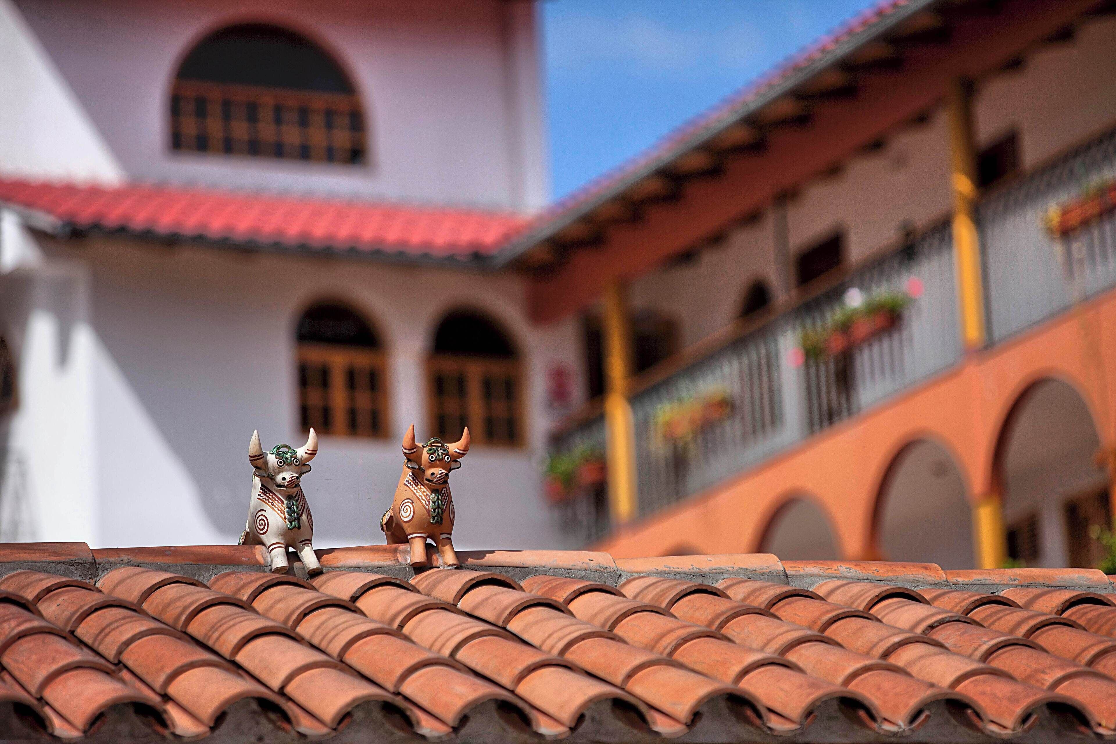 A terracotta-tiled roof with two decorative bull figures.