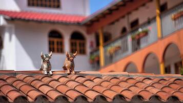 A terracotta-tiled roof with two decorative bull figures.