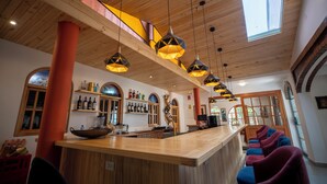 A bar area with wooden ceiling, pendant lighting, and a view of the outside through a skylight. - San Sebastian Hotel Boutique (Huaraz)