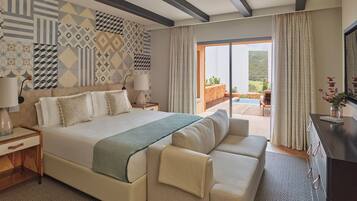 Ein geräumiges Schlafzimmer mit einem großen Bett, einer Couch, einem Fernseher und Blick ins Freie.