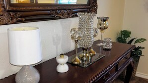 A wooden console table with a white lamp, crystal candle holders, and a mirror. - Charming 4-bedroom house with AC and WiFi in amazing Cedar Hill (Cedar Hill)
