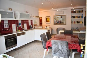 Enjoy cooking and dining in this well-equipped kitchen and dining area with a large table and comfortable seating.