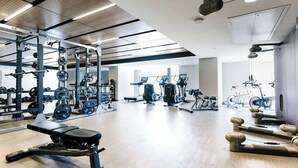 A gym with various exercise equipment including treadmills, weight machines, and free weights. - Midnight Rose-Your Elevated Stay! (Calgary)