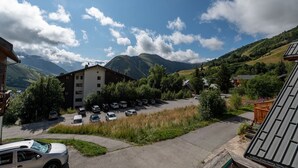 A building with a parking lot and a mountainous backdrop.