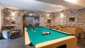 A pool table with billiard balls, a foosball table, and a stone wall. - Charming Villa Azul with Pool, Jacuzzi & Sauna (Sveti Vid Dobrinjski (Krk))