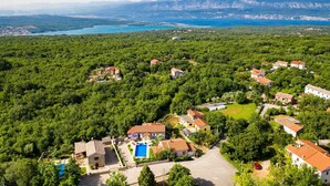 An aerial view of a residential area with houses, a swimming pool, and a view of a lake and mountains in the background. - Charming Villa Azul with Pool, Jacuzzi & Sauna (Sveti Vid Dobrinjski (Krk))