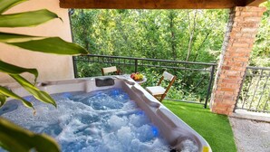 A hot tub with a view of a lush garden and a brick wall. - Charming Villa Azul with Pool, Jacuzzi & Sauna (Sveti Vid Dobrinjski (Krk))