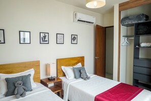 A hotel room with two beds, a wardrobe, and a bedside table with a lamp. - Warm Haven in Puerto Vallarta 2 Bedrooms (Puerto Vallarta)