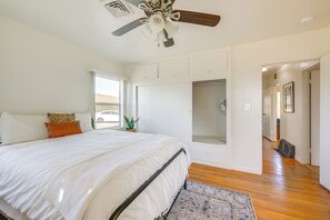 Ein Schlafzimmer mit einem großen Bett, einem Deckenventilator, einem Fenster und Blick ins Freie.