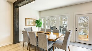 A dining room with a wooden table and patterned chairs, large windows, and a view of the outdoors. - Fish, Boat & Unwind: Old Hickory Lake Retreat (Mt. Juliet)