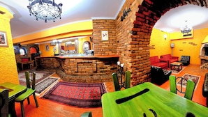 A restaurant with brick walls, wooden tables, and a fireplace. - Casa Oasa  (Koper)