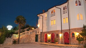 A two-story building with a stone facade, red doors, and a balcony. - Casa Oasa  (Koper)
