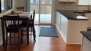 Una cocina con comedor, piso de madera y vistas por un ventanal.