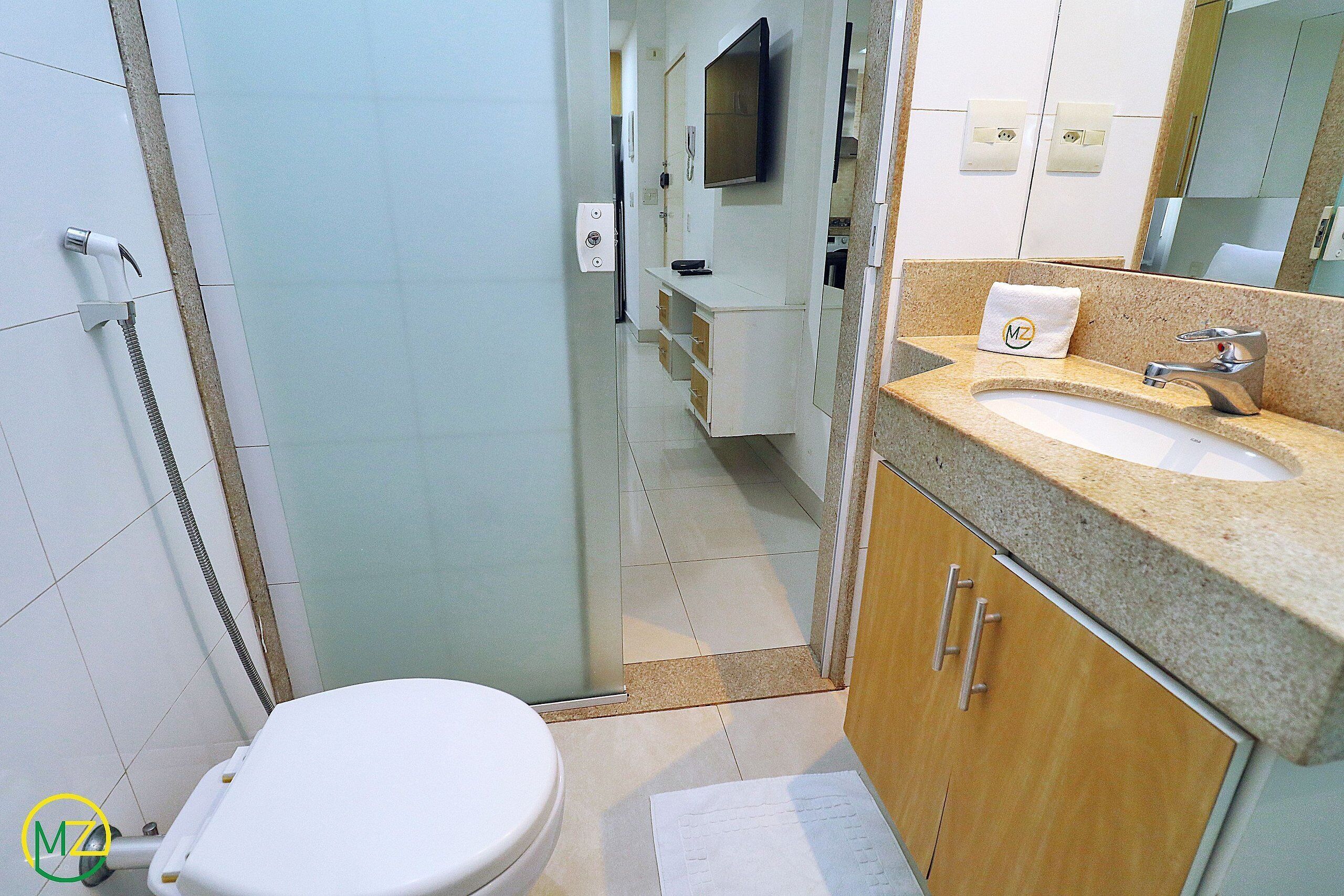 A bathroom with a toilet, sink, and shower.