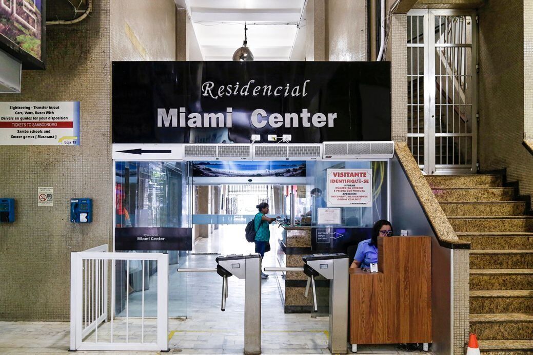 Zona de registro en Miami Center con un mostrador de recepción, una escalera y un cartel que indica que es una zona residencial.