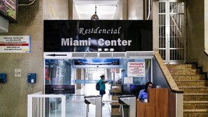 A check-in area at the Miami Center with a reception desk, a staircase, and a sign indicating it is a residential area. - Prado X (Rio de Janeiro)