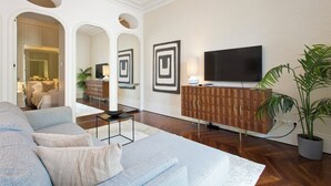 Un salon moderne avec un canapé, un téléviseur et des miroirs décoratifs.