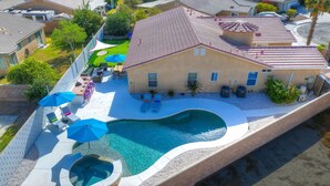 A residential property with a swimming pool, outdoor seating, and a covered patio area. - Twilight Tunes - Pool, Glowing Arcade Experience (Indio)