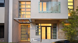 A modern building with a glass balcony, a decorative door, and a sign with the number 19. - Cozy 3-bedroom house with Wifi/AC and only mins from cafes and perth cbd. (Subiaco)