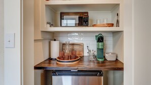 Eine kleine Küche mit Mikrowelle, Kaffeemaschine und Geschirrspüler.