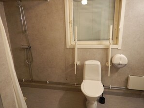 Un baño con inodoro, ducha y ventana.