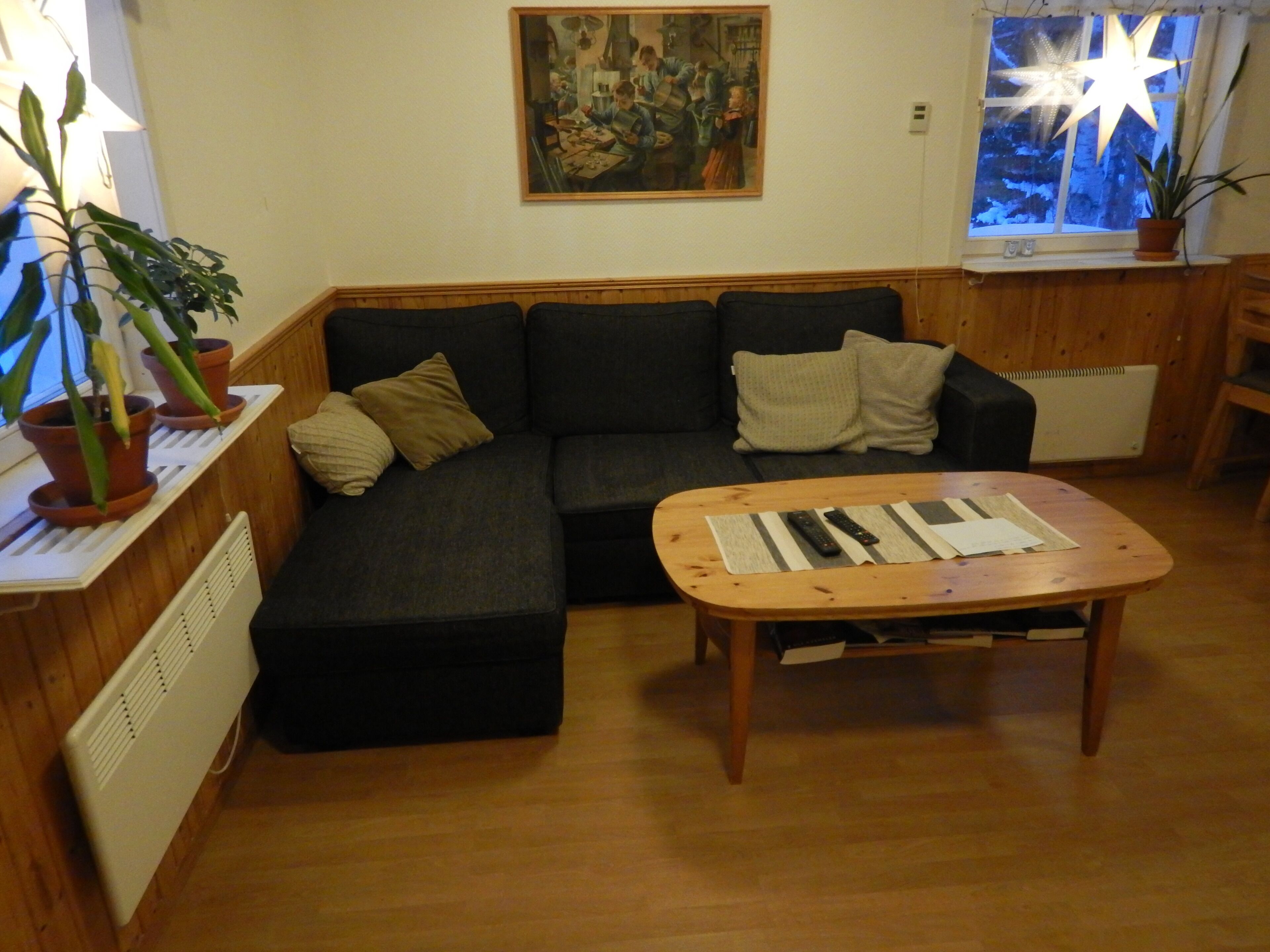 Una sala de estar acogedora con un sofá modular, una mesa de centro y plantas en macetas.