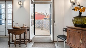 A room with a wooden table, a chair, a cabinet, and a vase with flowers.