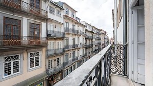 Une rangée d’immeubles à plusieurs étages dotés de balcons, une promenade piétonne et un ciel dégagé.