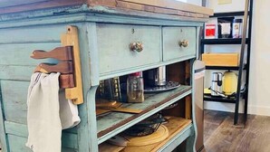 A rustic wooden cabinet with drawers and shelves, a hanging towel, and a chalkboard sign on the wall. - Highland: Driftless Fun Awaits (Highland)