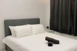 Restful retreat with a neatly made bed and a touch of greenery.