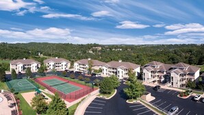Un complexe résidentiel comprenant plusieurs immeubles d’appartements, un court de tennis et une piscine.