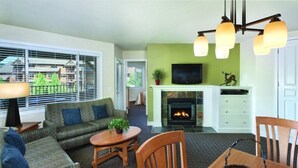 Una sala de estar con chimenea, sofá y mesa de comedor.