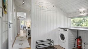 A laundry room with a washing machine, a fire extinguisher, and a window with a view of trees. - 3 bedroom nice home in Fjerritslev (Fjerritslev)