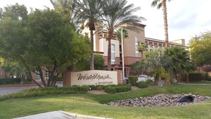 Señal de hotel con el nombre 'Wyndham' y un edificio al fondo.