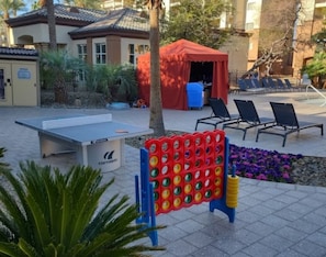 En gårdhave med et pingpongbord, et legeområde for børn og udendørs siddepladser.