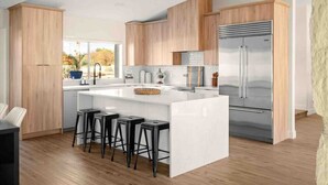Una cucina moderna con una grande isola, elettrodomestici in acciaio inossidabile e mobili in legno.