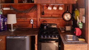 A compact kitchen with a stove, sink, and refrigerator. - Beachfront Tiny Home on the La Fortuna Surf Break - The Baja Station (San José del Cabo)