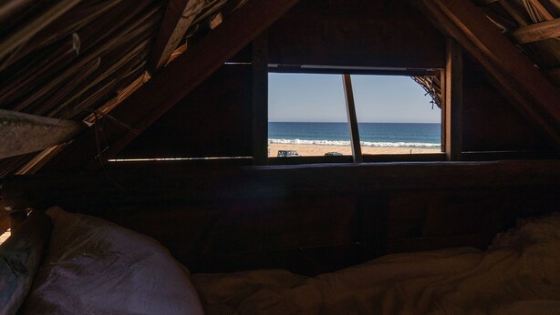 A bedroom with a view of the beach through a window. - Beachfront Tiny Home on the La Fortuna Surf Break - The Baja Station (San José del Cabo)