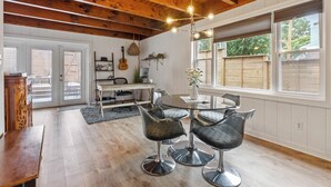 Un área de comedor con una mesa redonda y cuatro sillas, techo de madera y una ventana con vistas al exterior.