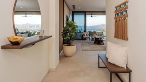Ein modernes Interieur mit einem großen Fenster, einem Blumentopf, einer Bank und einem Wandbild.