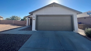 A residential house with a garage, a driveway, and a clear sky. - Eastside Tucson Gem (Tucson)
