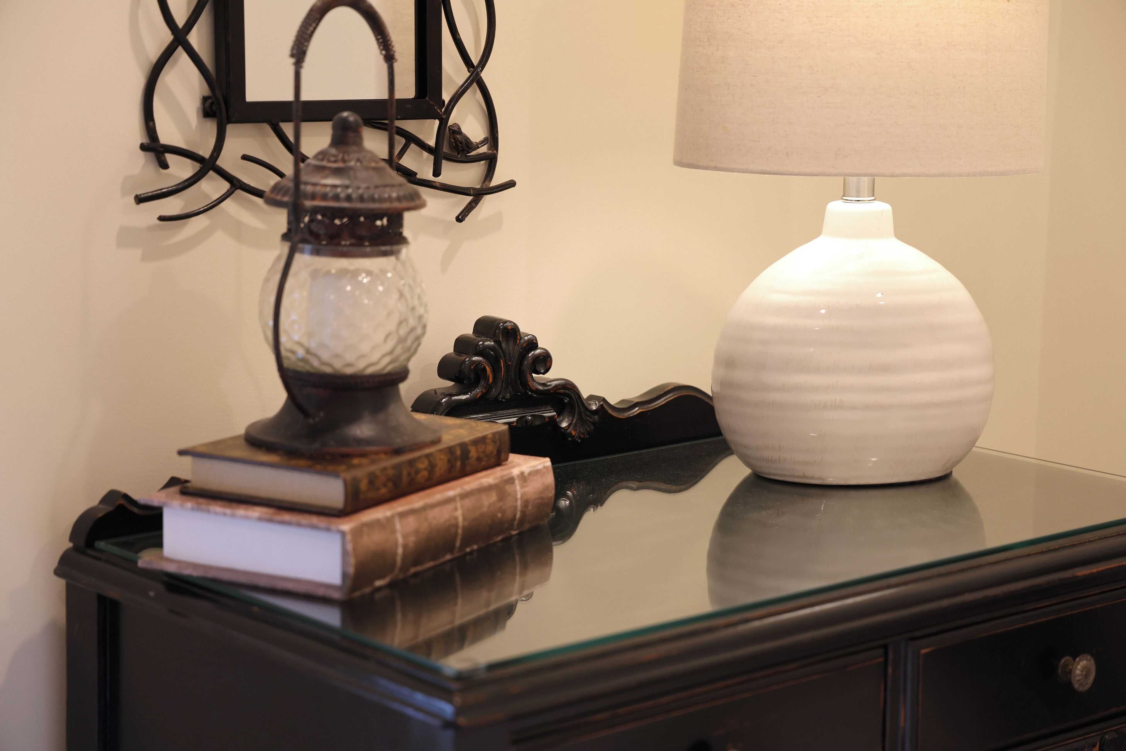 Une table avec une lampe, un vase et des livres.