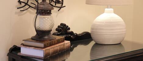 Une table avec une lampe, un vase et des livres.